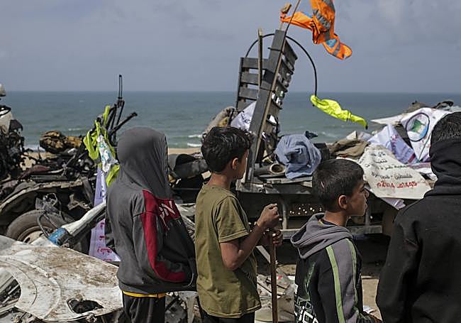 Jóvenes palestinos esperan para recoger ayuda humanitaria en una playa de la Franja.