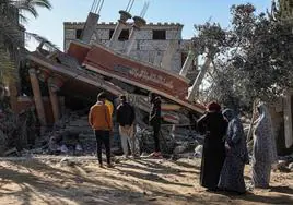 Un grupo de palestinos revisa los escombros de una vivienda alcanzada por un bombardeo israelí en Khan Yunis.