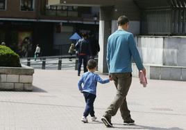 Un padre con su hijo de la mano tras recogerle del colegio.