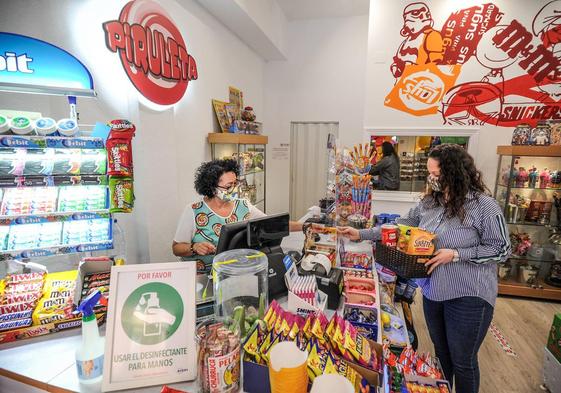 Una mjujer al frente de un pequeño comercio.