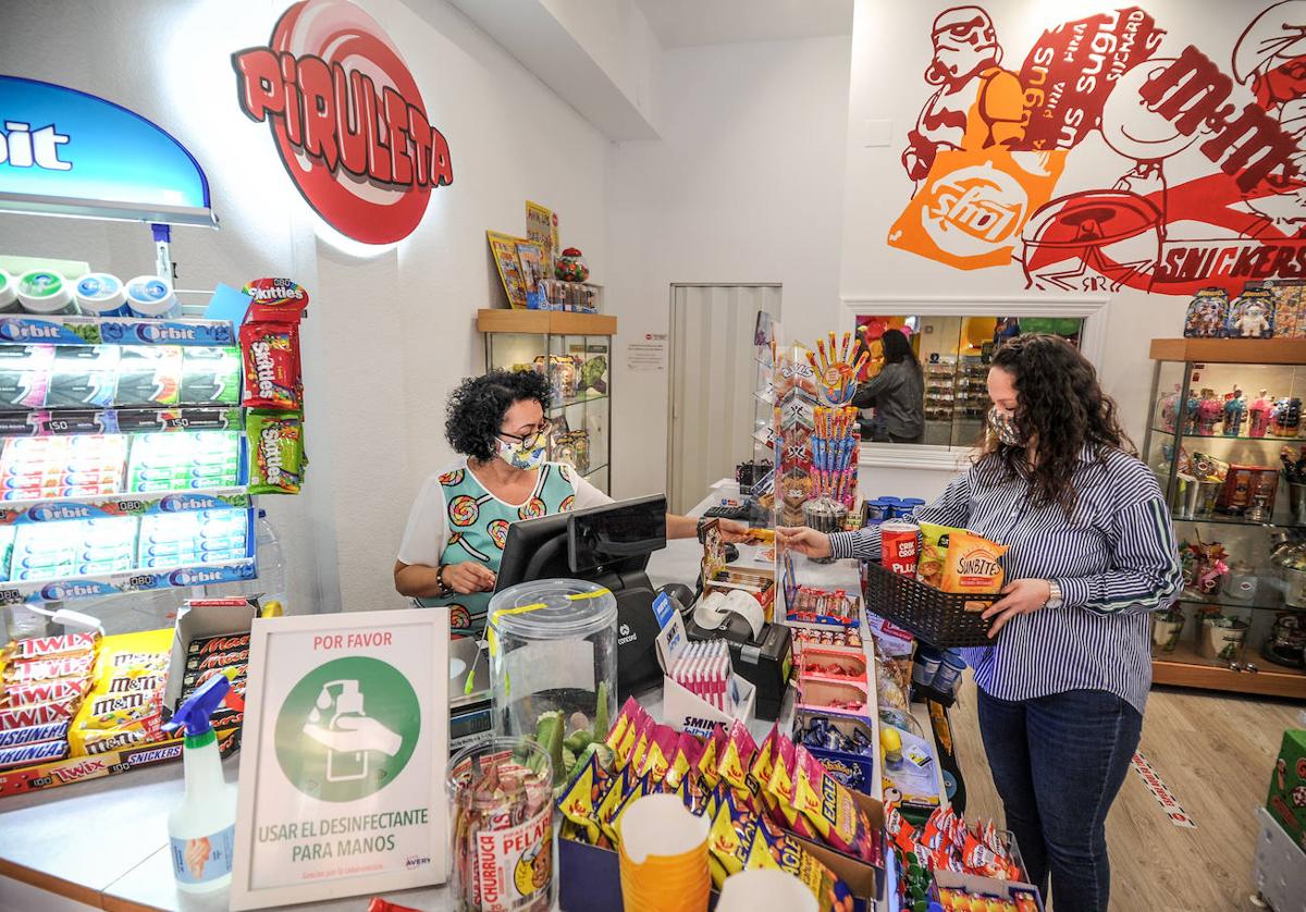 Una mjujer al frente de un pequeño comercio.