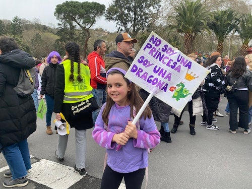 Una niña, de Gijón, sostiene una pancarta en la que puede leerse: «no soy una princesa, soy una dragona»