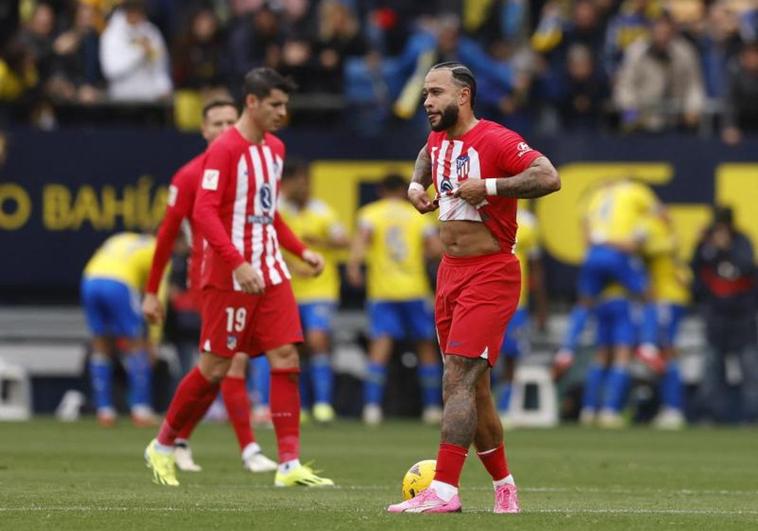 Los rojiblancos Memphis y Morata se lamentan mientras los gaditanos celebran el primer gol.