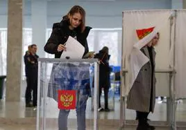 Una joven deposita su voto en una urna en Moscú.