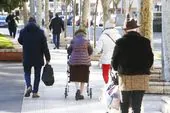 Varias personas mayores caminan por una calle de Bilbao.