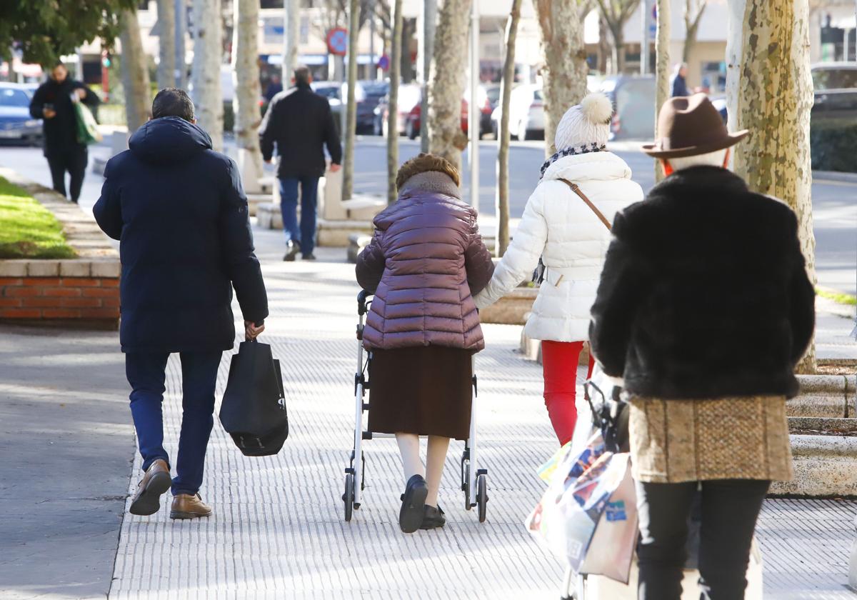 Varias personas mayores caminan por una calle de Bilbao.