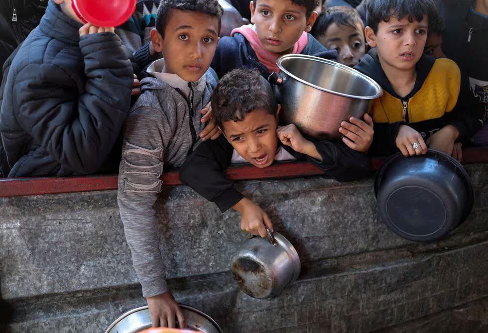 Bir grup çocuk Refah'ta yiyecek almak için bekliyor.