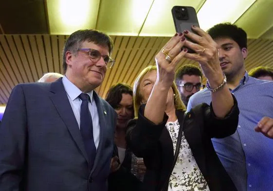 Carles Puigdemont (izquierda) se hace un selfi con una simpatizante independentista tras su conferencia este jueves en la localidad francesa de Elna.