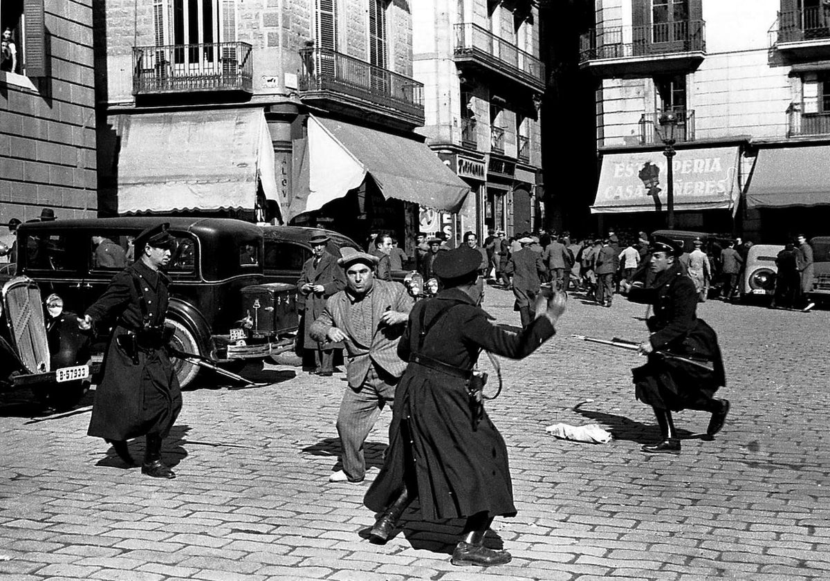 Un manifestante es golpeado por guardias de asalto republicanos durante unos disturbios en la Plaza de Sant Jaume, Barcelona.