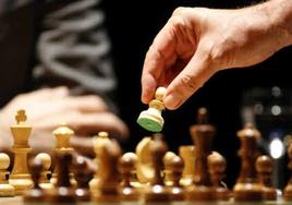 Un jugador de ajedrez mueve un peón.