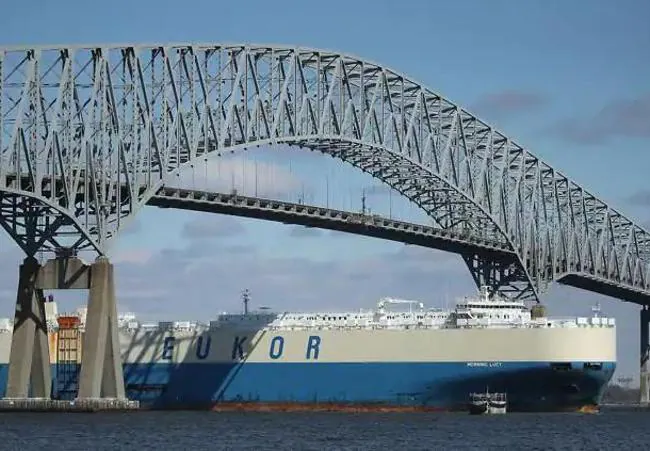 Hasarlı köprünün altından geçen bir yük gemisinin görüntüsü.