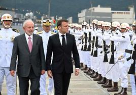 Macron y el presidente Lula da Silva pasan revista a las tropas durante una visita a una base naval de Brasil.