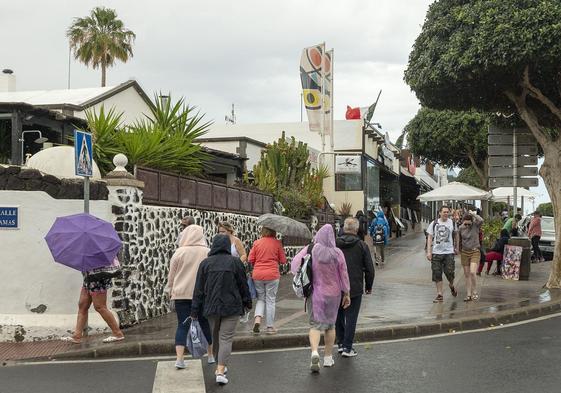 Turistas con chubasqueros y paraguas en Lanzarote.