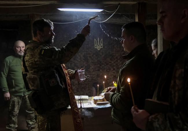 Un capellán militar rocía agua bendita a un soldado durante un servicio de Pascua ortodoxo, en abril de 2023.