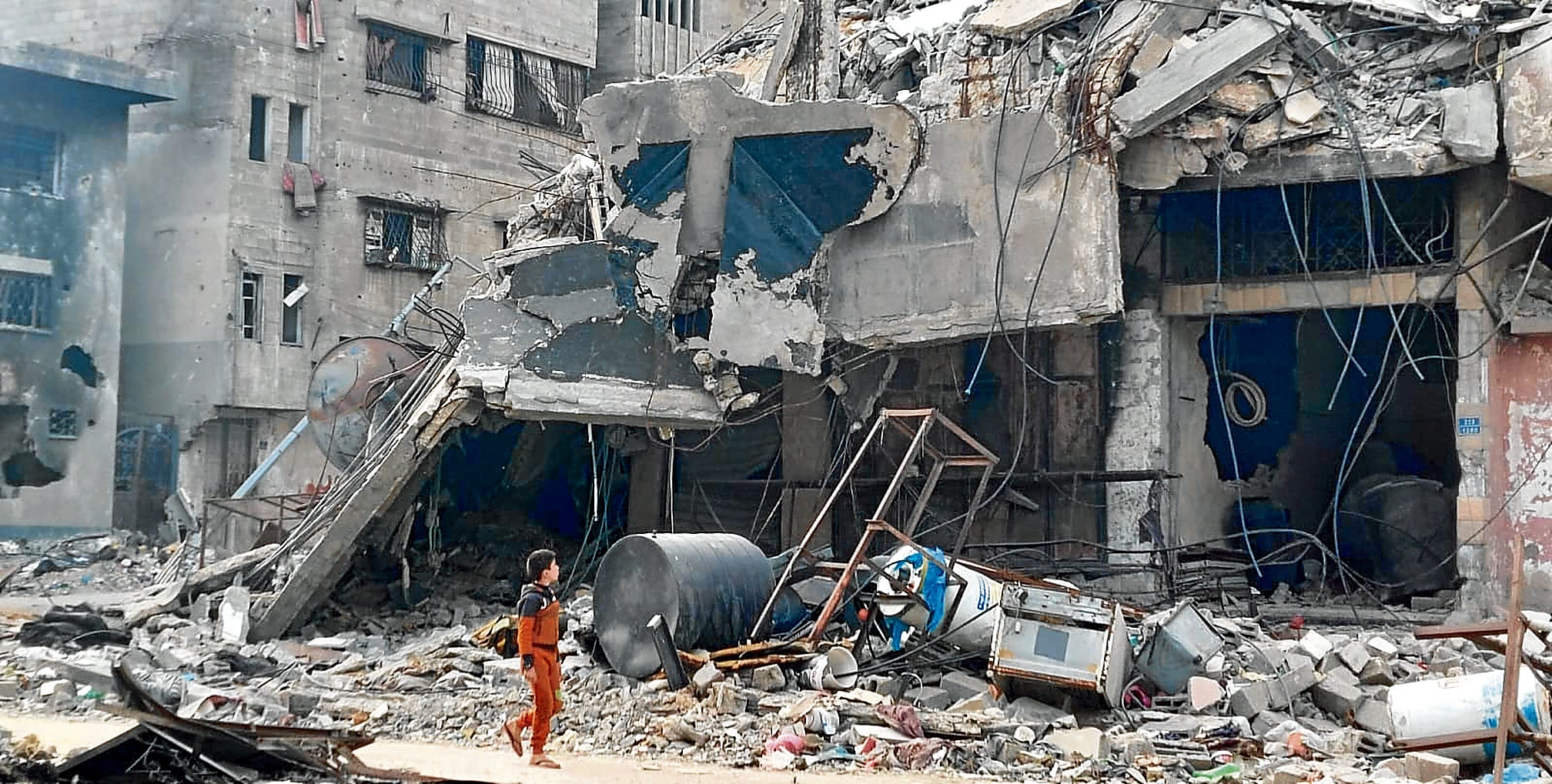 Un niño pasea junto a un edificio en ruinas en Gaza.