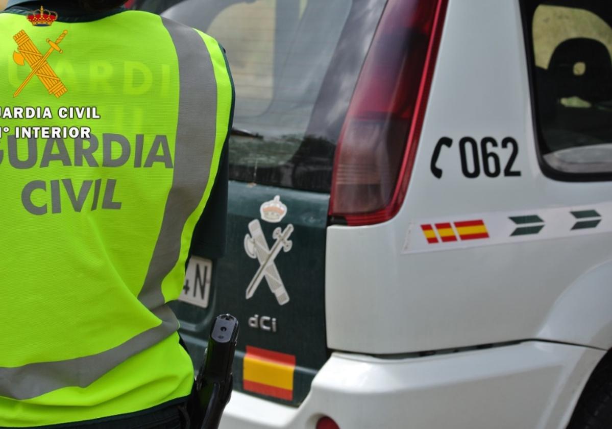 Un agente de la Guardia Civil junto a uno de sus coches