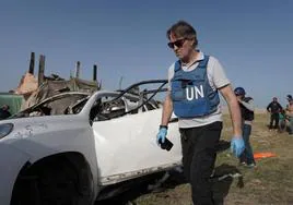 Un forense de la ONU examina uno de los vehículos de World Central Kitchen.