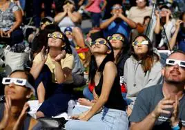 Un grupo de jóvenes observa el eclipse solar en el Observatorio Griffith en Los Ángeles, California.