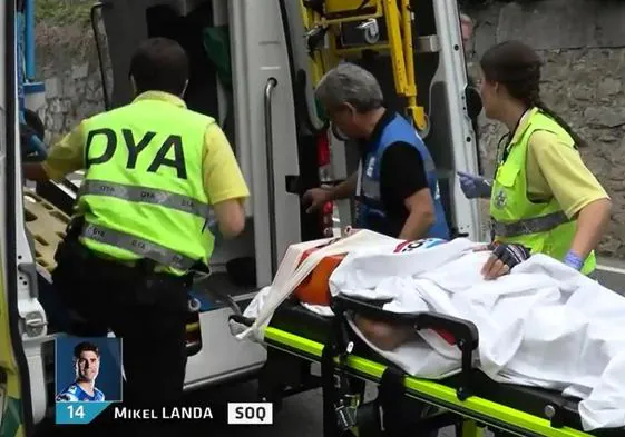 Mikel Landa trasladado en camilla e inmovilizado a una ambulancia.