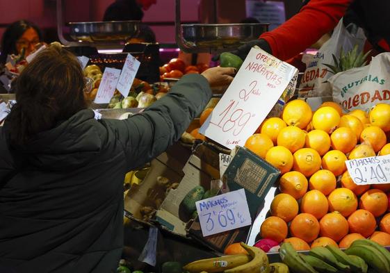 Una mujer compra fruta en un puesto de Madrid.