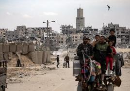 Un grupo de palestinos transita por una de las calles en ruinas de Jan Younis.