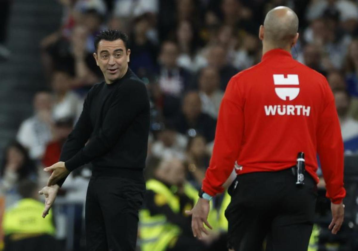 Xavi Hernández se dirige al cuarto árbitro durante el clásico disputado el domingo en el Bernabéu.