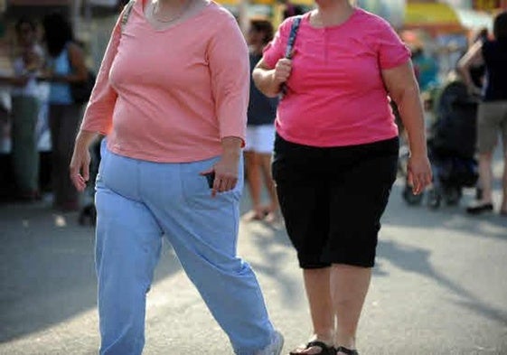 Dos mujeres caminan por la calle.