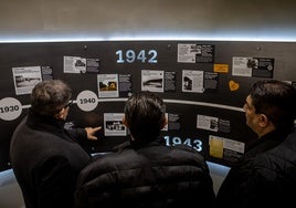 Visitantes al nuevo museo observan un panel histórico sobre la represión nazi.