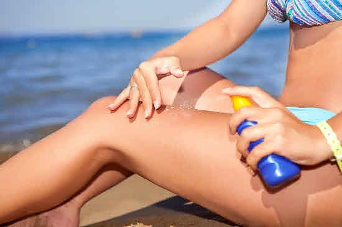 Una mujer se aplica crema protectora solar.