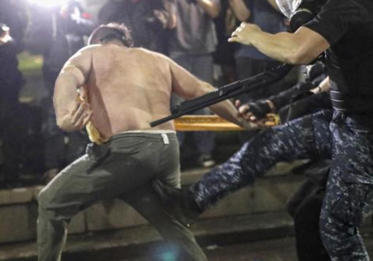 La Policía antidisturbios arremete contra un manifestante frente al Parlamento en Tiflis.