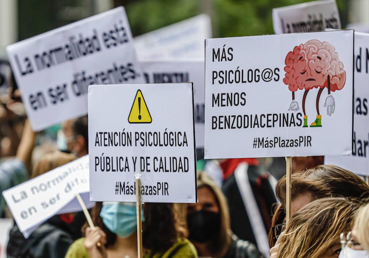 Varias personas sostienen diferentes pancartas en una marcha con motivo del Día Mundial de la Salud Mental.