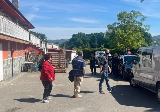 La propietaria del inmueble y casera de los sospechosos conversa con los agentes de la Policía Nacional, junto al jardín.