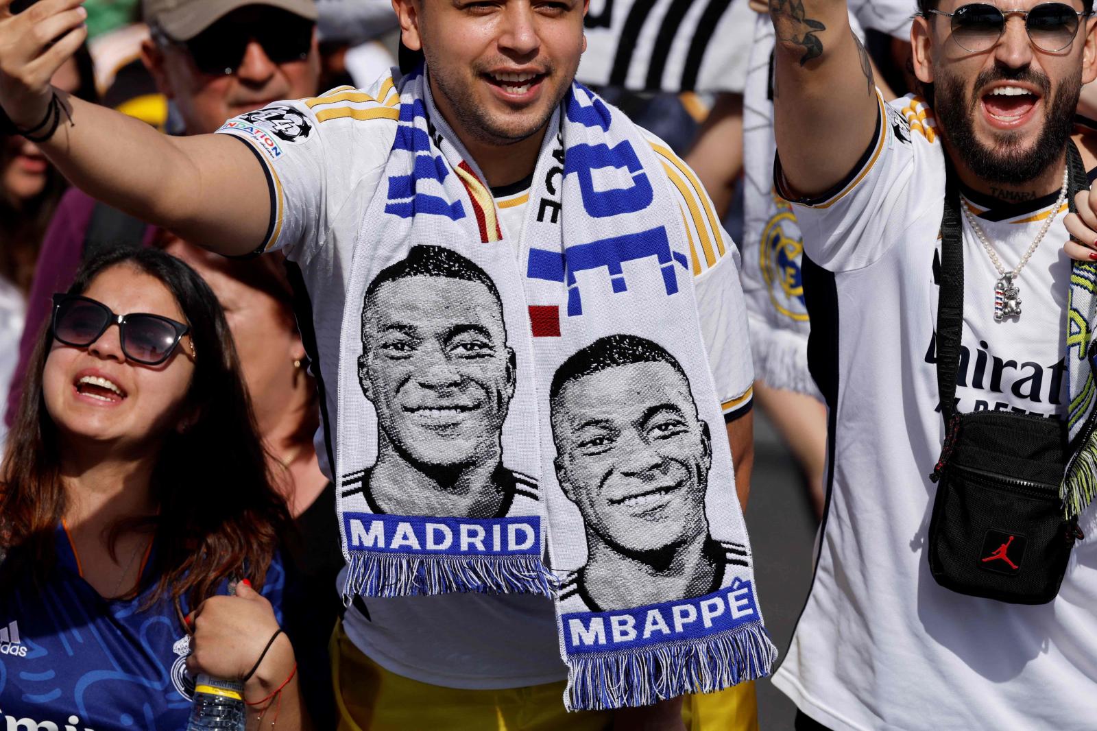 Fans del Madrid celebran la liga con bufandas con la cara d Mbappé. Hay ganas de que llegue el francés al equipo