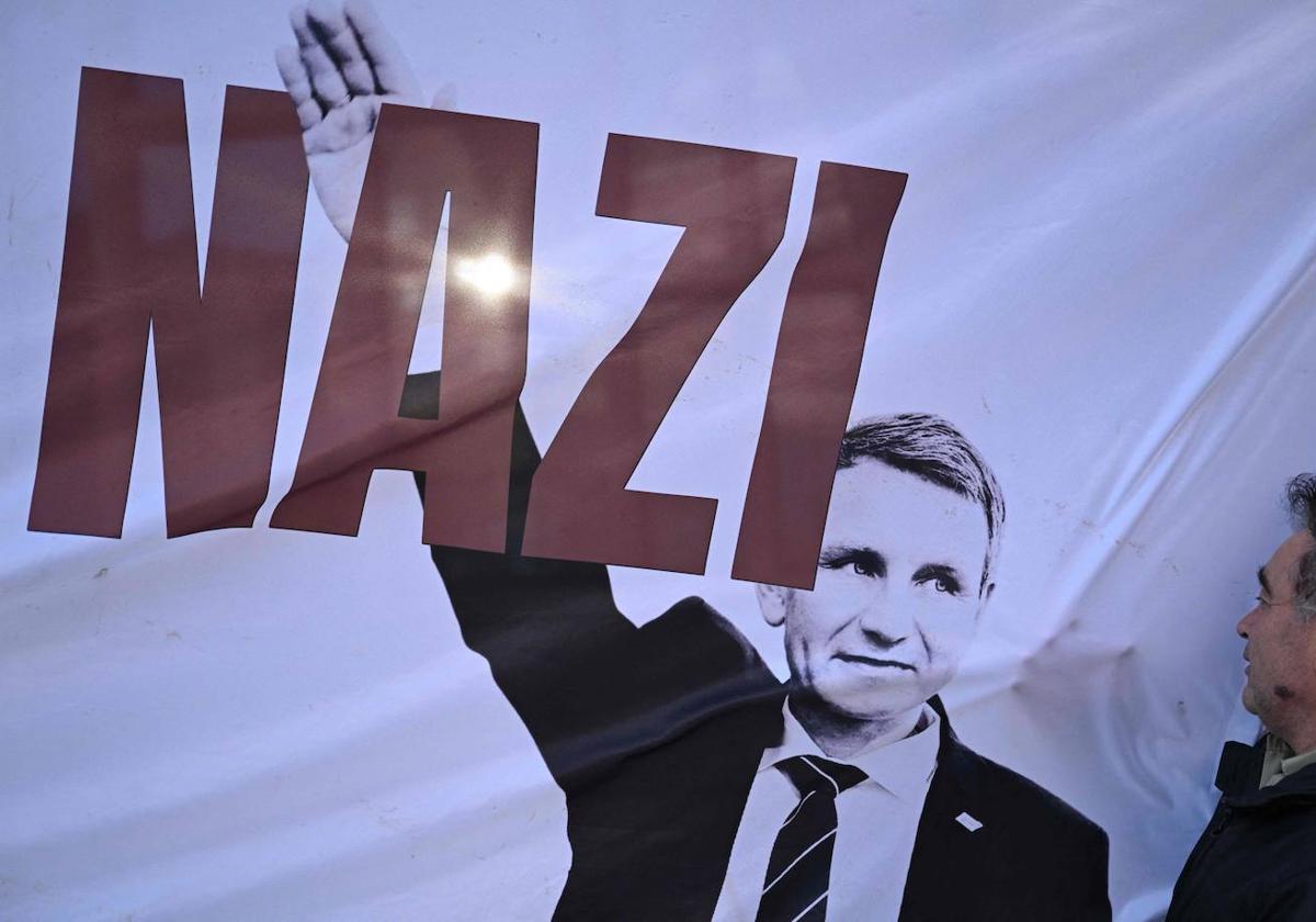 Un manifestante mira una pancarta que representa al ultraderechista Björn Höcke.