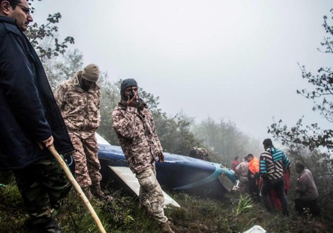 Rescatistas trabajan junto a restos del fuselaje del helicóptero.