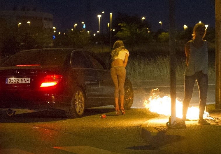 Varias mujeres se prostituyen junto a la carretera en una barriada de las afueras de Madrid.