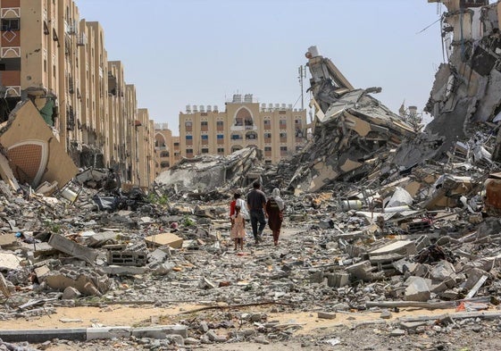 Palestinos caminan entre las casas destruidas en la ciudad de Hamad, en Gaza.