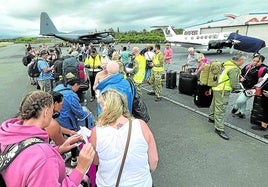 Turistas hacen cola en el aeropuerto de Magenta para ser evacuados en un avión militar neozelandés.