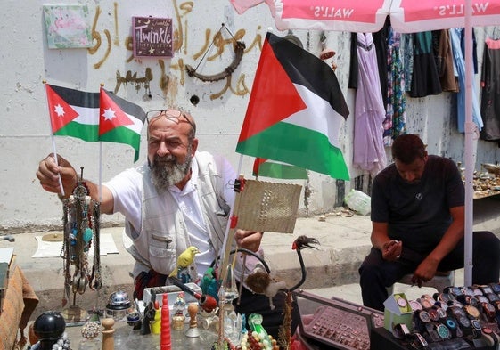 Un hombre coloca una bandera jordana junto a una palestina en el campo de refugiados de Baqa'a, cerca de Ammán.