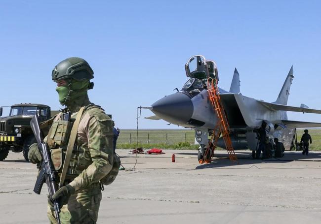 Un militar ruso hace guardia cerca de un caza MiG-31 con un misil nuclear, durante las maniobras que llevan a cabo estos días.