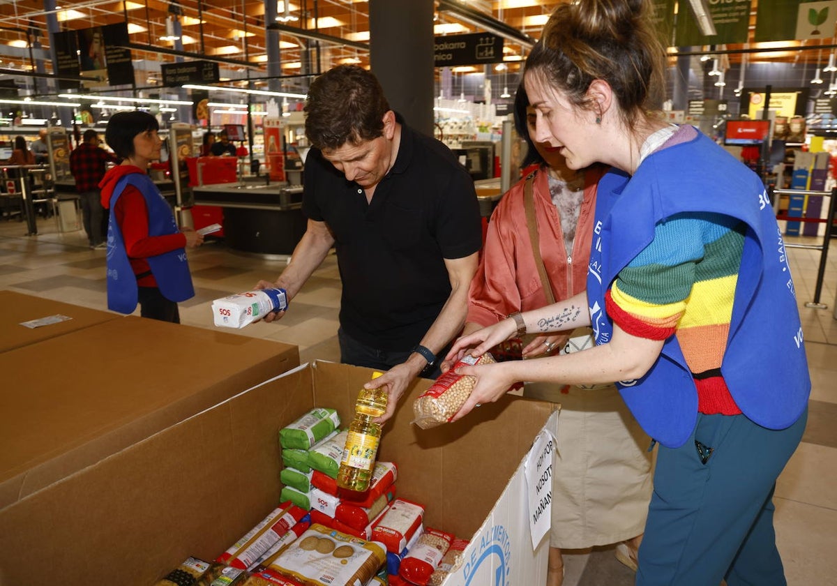 Voluntarios del Banco de Alimentos de Álava recogen comida donada en un hipermercado.