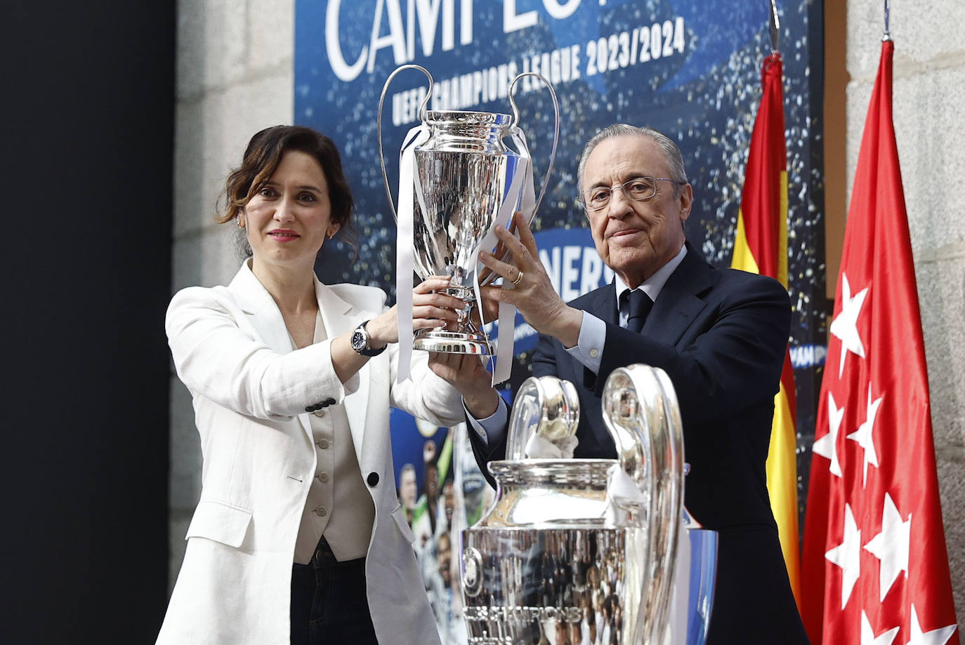 Isabel Díaz Ayuso, presidenta de la Comunidad de Madrid, sostiene una réplica en pequeño de la 'orejona' junto a Florentino Pérez, presidente del Real Madrid.