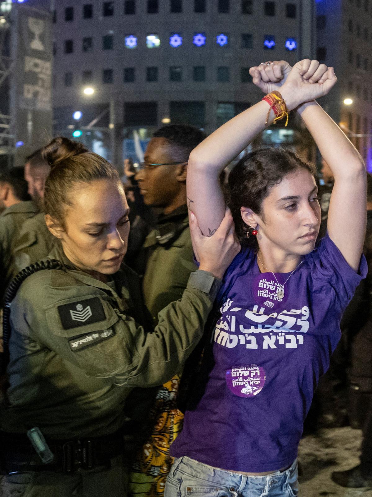 Una oficial aparta a una joven participante en la multitudinaria manifestación contra Netanyahu en Tel Aviv.