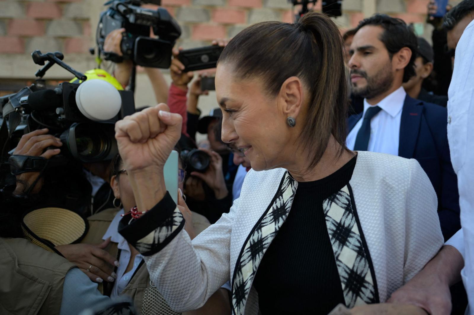 Claudia Sheinbaum hace un gesto de triunfo ante los medios.