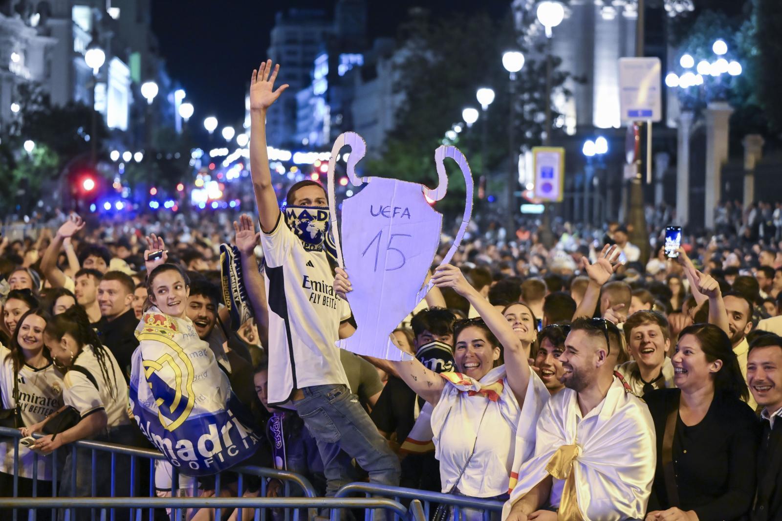 Unos aficionados sujetan una copa de cartón que recrea la Decimoquinta.