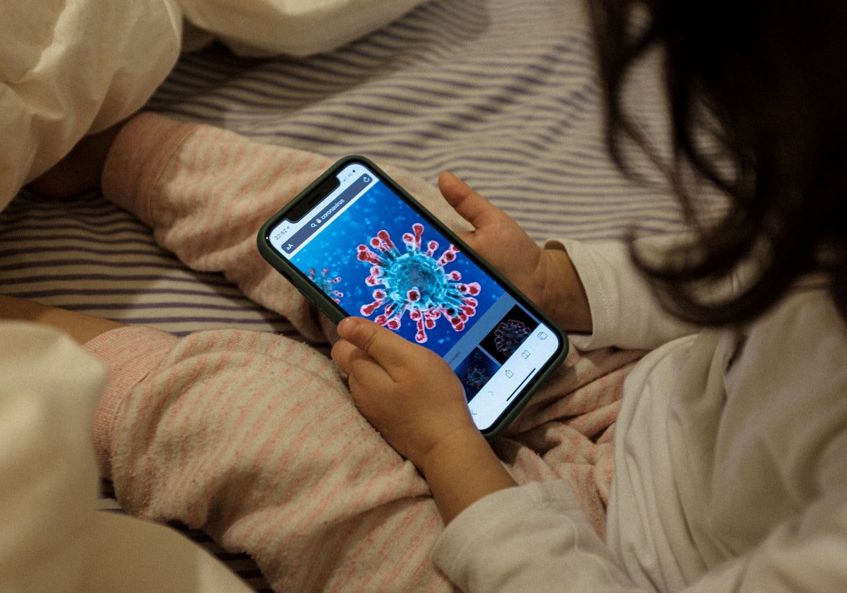 Una niña juega con un teléfono móvil.