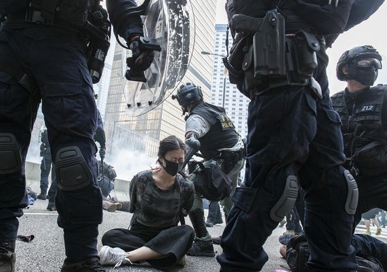 Una joven manifestante es arrestada en Hong Kong.