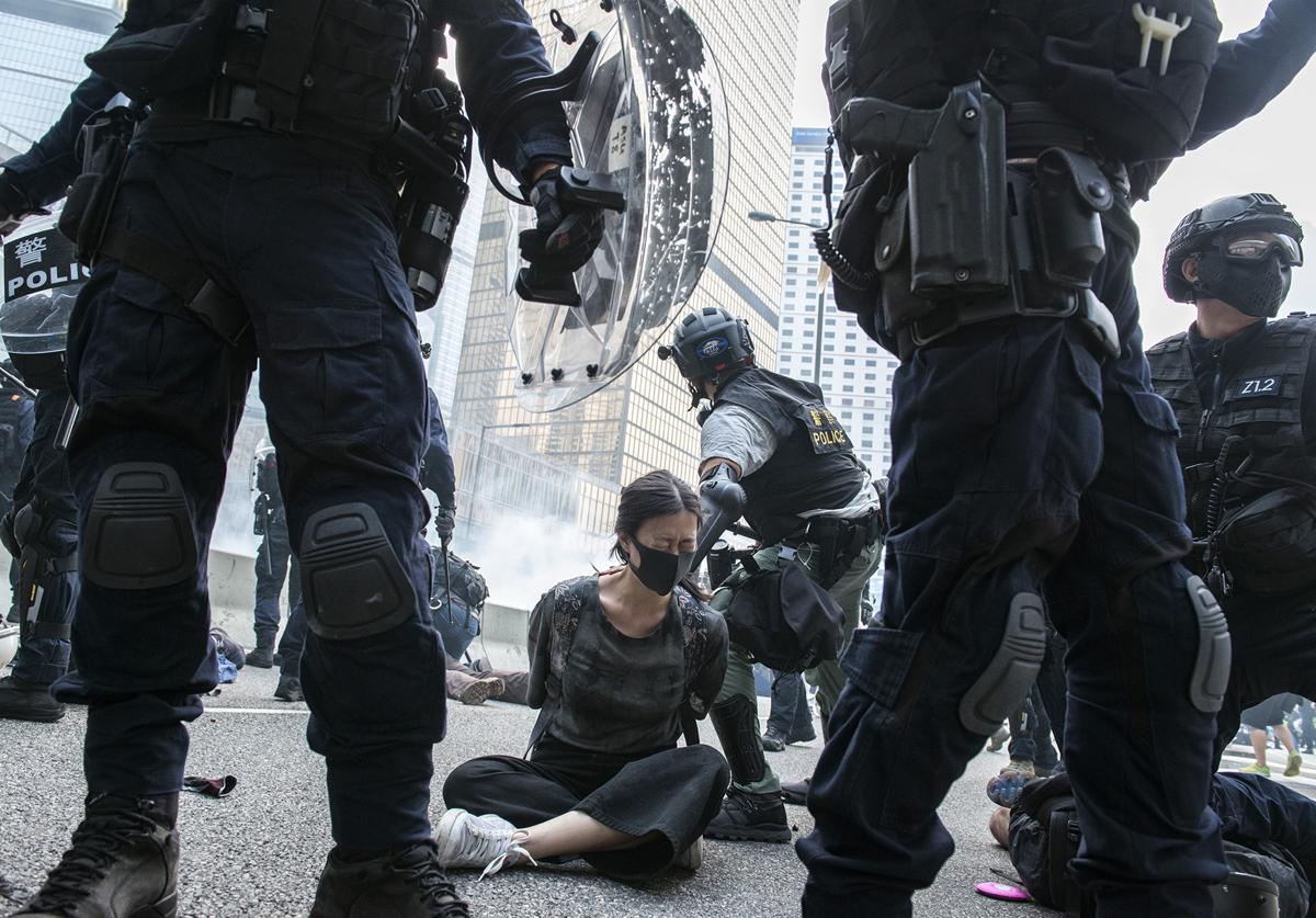 Una joven manifestante es arrestada en Hong Kong.