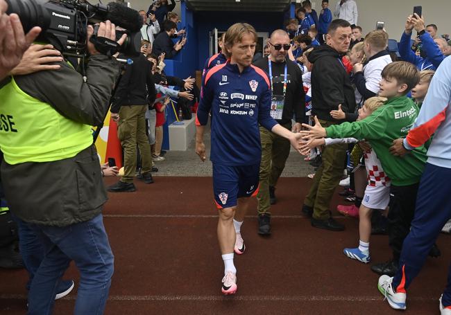 Luka Modric saluda a un niño en el campo de entrenamiento de Croacia.