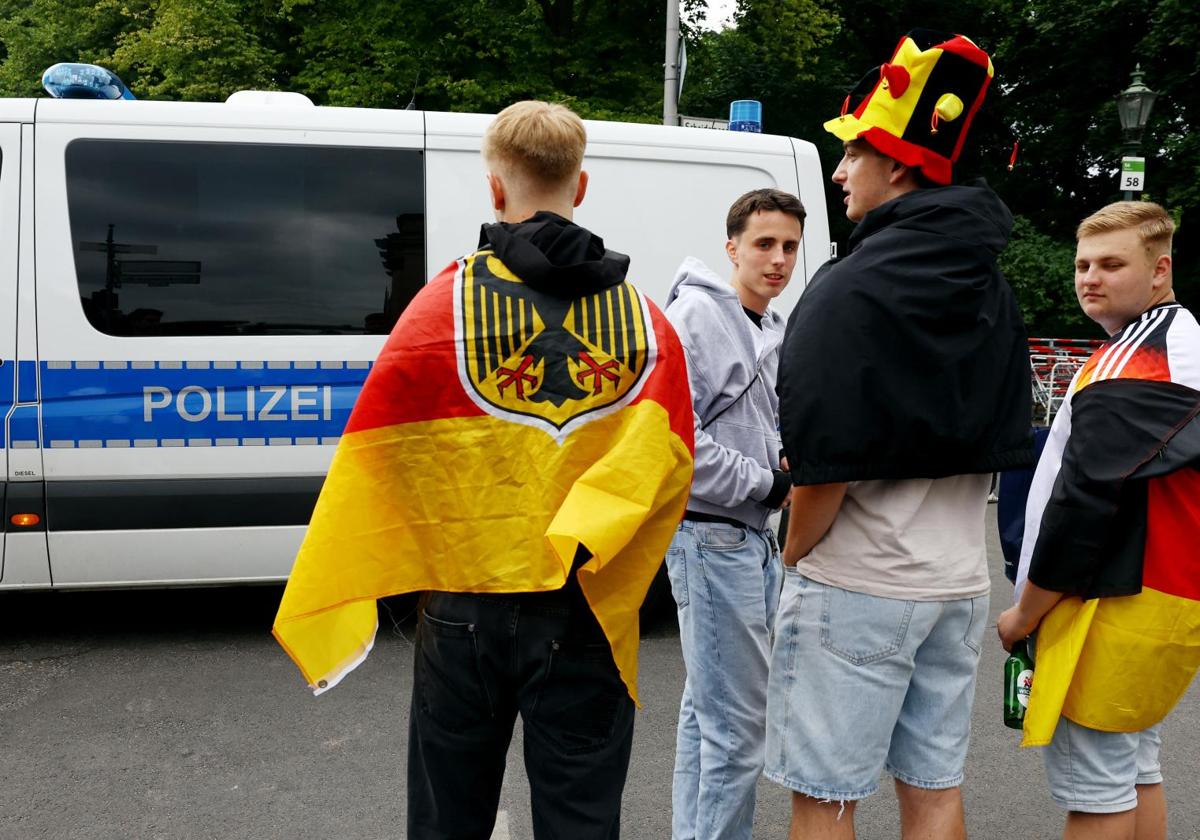 Aficionados alemanes observan el despliegue policial en la 'fan zone'.